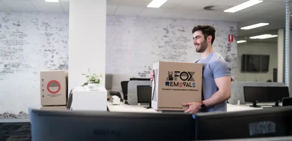 fox removals team member moving boxes in an office